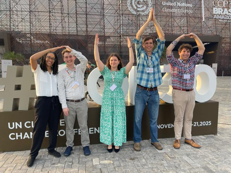 Five OSU students and staff spelling Ohio in front of the COP30 building in Brazil