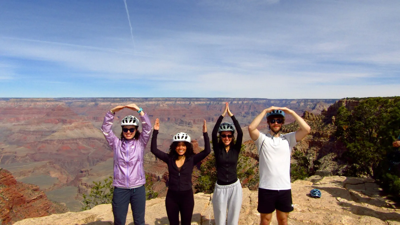 Four students standing at the edge ofthe Grand Canyon forming O-H-I-O