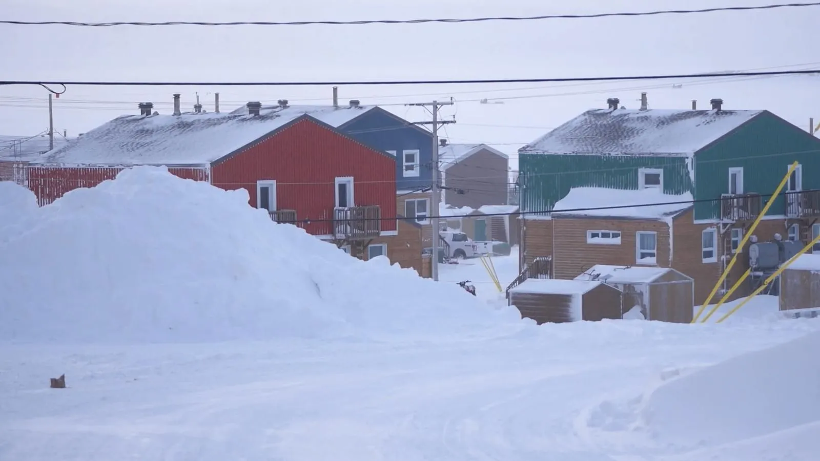 Settlement partially obscured by piles of snow
