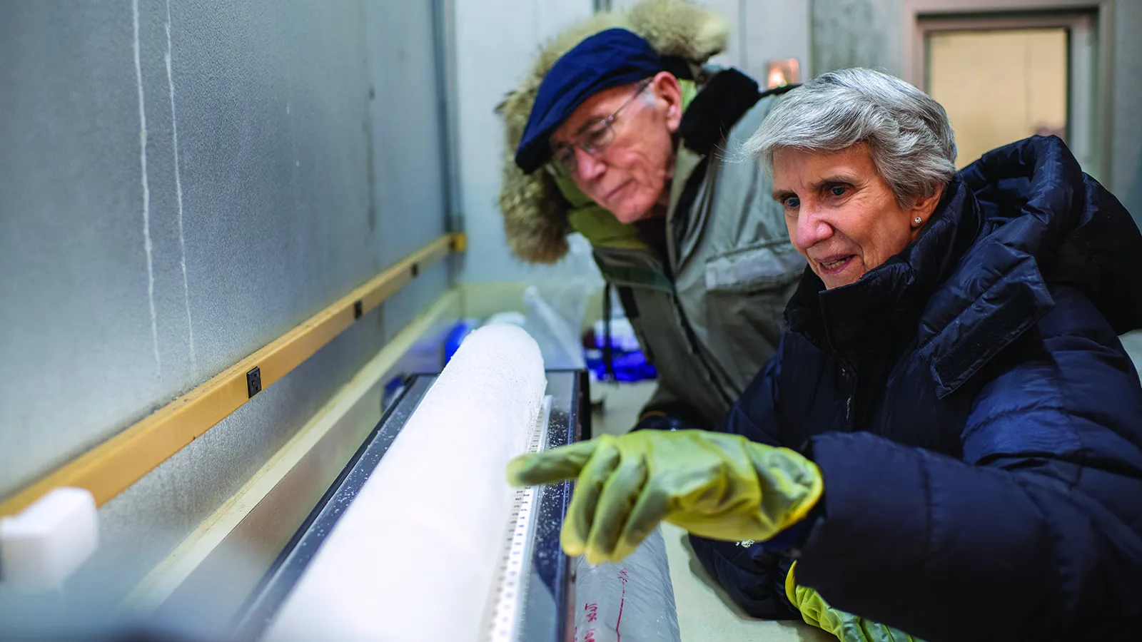 Two professors in winter coats examine a polar ice core