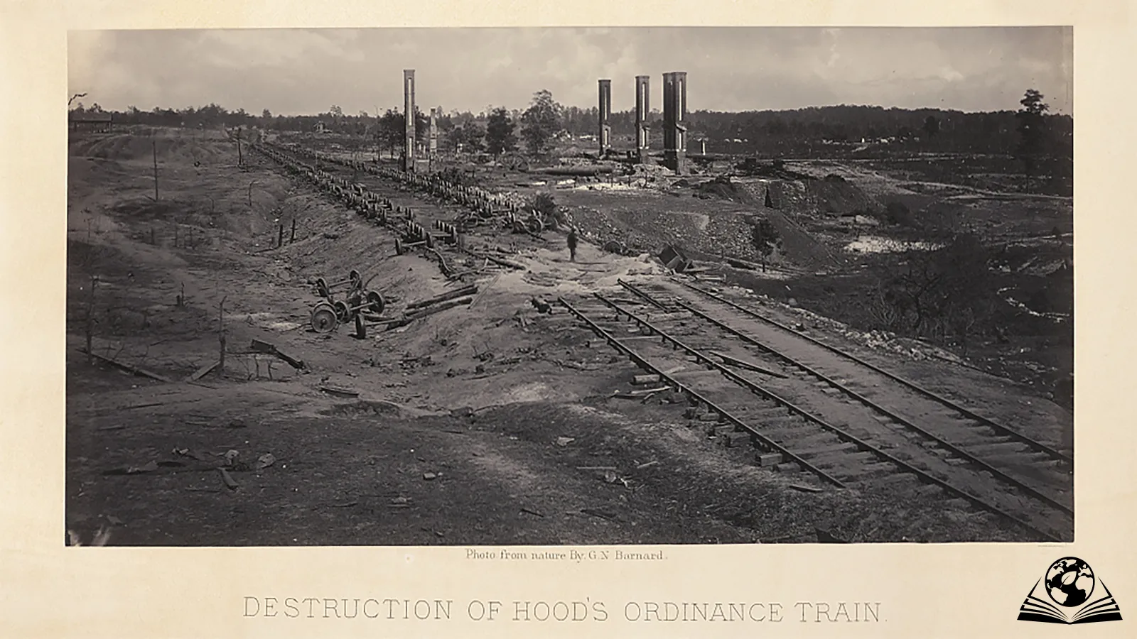 Black and white photograph depicting a ruined railyard