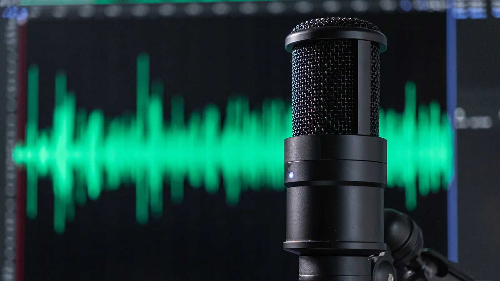 Microphone in front of a monitor displaying audio editing software