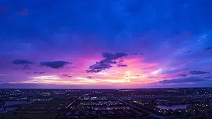City at sunset below a colorful sky
