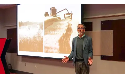 Kip Curtis presenting by a projection screen